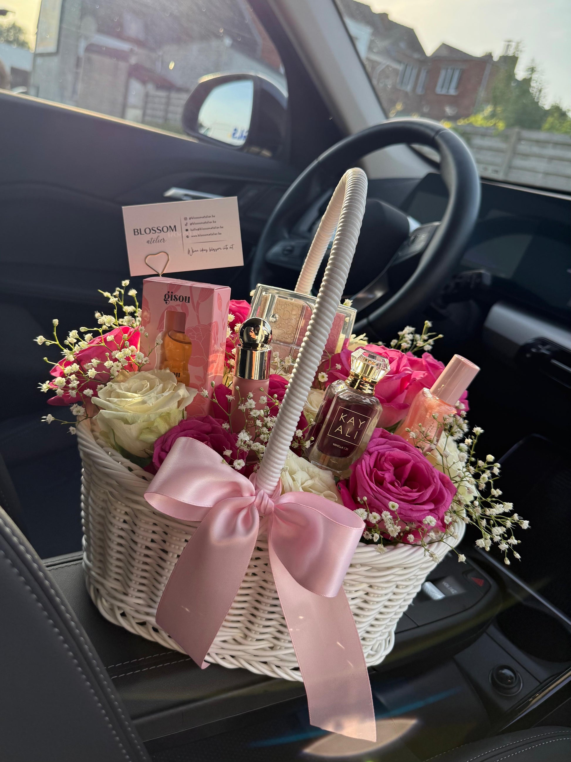 Gift basket with flowers and perfumes inside a car